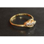 An 18 Carat Gold and Platinum Set Five Stone Diamond Ring of crossover form