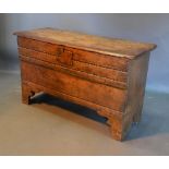 A George III Oak Coffer, the hinged top above a carved front raised upon bracket feet, 107cm wide,