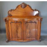 A 19th Century Mahogany Serpentine Chiffonier with a carved shaped back above two doors raised