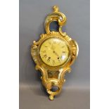 A Giltwood Cartel Clock of scroll form, the dial with Roman and Arabic numerals and with two train