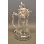 A Glass and Silver Plated Claret Jug with lion surmount and engraved with grapevines, 27cm tall