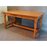 An Early 20th Century Elm Refectory Style Dining table, the plank top above a plain frieze raised