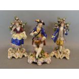 A Pair of 19th Century Chelsea Figures in the form of a lady and gentleman before bocage, together