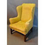 A Late 19th/Early 20th Century Wingback Armchair with square legs and stretchers