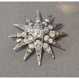 A White Gold Brooch in the form of a star with central diamonds surrounded by diamonds, 3cm diameter