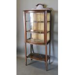 An Art Nouveau Mahogany Display Cabinet with a bow-fronted lead glazed door enclosing shelves raised