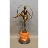 An Art Deco Style Patinated Bronze Model in the form of a dancing girl with hoop upon variegated