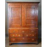 A George III Oak Bacon Cupboard, the moulded cornice above two panel doors, the lower section with