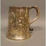 A George II Newcastle Silver Mug of tapering form with embossed foliate decoration and shaped