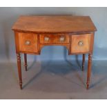 A Regency Mahogany Bow-Fronted Side Table with three drawers, circular brass handles, raised upon