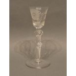 An 18th Century Cordial Glass with a foliate engraved bowl above a spiral twist double knopped