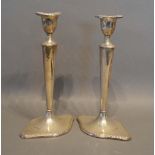 A Pair of Edwardian Silver Candlesticks with shaped bases, London 1907, 22cm tall