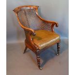 A Regency Mahogany Armchair with a cane back and sides raised upon turned legs with brass caps and