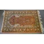 A North West Persian Silk Prayer Rug with an allover design upon a red, blue and cream ground within