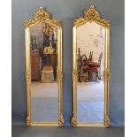 A Pair of Gilded Dressing Mirrors, each with pierced scroll cresting and corner mounts, 179 x 56cm