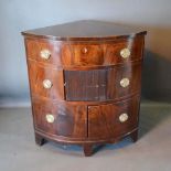 A 19th Century Mahogany Corner Cabinet with a drawer above a tambour and two doors with oval brass