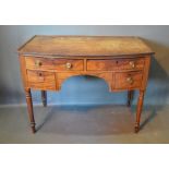 A 19th Century Mahogany Bow-Fronted Side Table with four drawers with brass knob handles raised upon