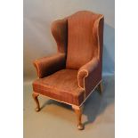 An Early 20th Century Wingback Armchair with cabriole legs and pad feet