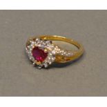 A 9 Carat Gold Ring of Heart Form with a red stone surrounded by diamonds