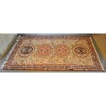 A North West Persian Woollen Rug with four central medallions within an allover design upon a red,