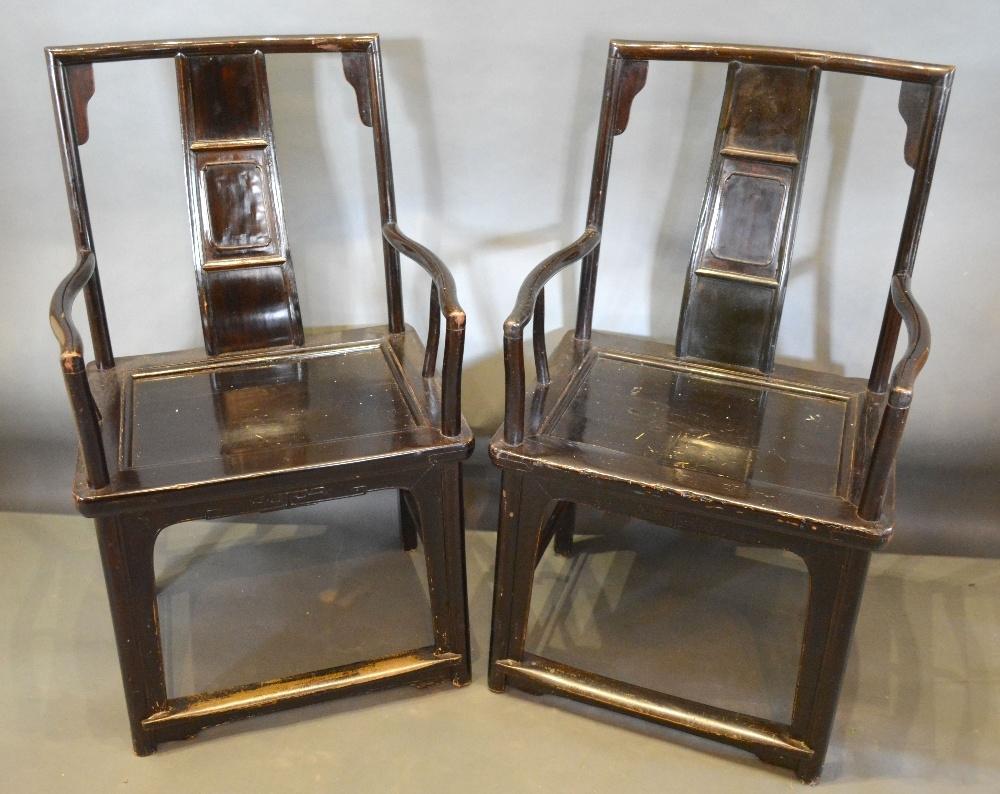 A Pair of 19th Century Chinese Hardwood Armchairs, each with a carved back above a panel seat,
