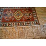 A 20th Century Woollen Rug with three medallions within an allover design upon a red, blue and cream