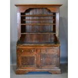 A George III Pine Dresser, the moulded cornice above a boarded shelf back, the lower section with