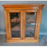 A Victorian Mahogany Pier Cabinet, the moulded top above two glazed doors enclosing shelves,