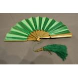 A Gilded Wooden Fan with plain green satin leaf, 17cm long