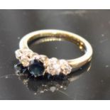 A Yellow Metal Five Stone Ring with a central sapphire flanked by four diamonds, 2.8 grammes