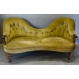 A Victorian Rosewood Double Spoonback Sofa with a button upholstered back above a stuff over seat