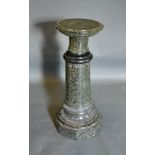 A Variegated Marble Torchere with a circular top above a cylindrical column and octagonal base, 62cm