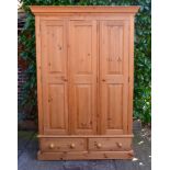 A 20th Century Pine Wardrobe, the moulded cornice above three panel doors above two drawers raised