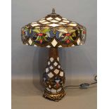 A Tiffany Style Glass and Metal Mounted Table Lamp with shade, raised upon circular pierced base,