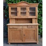 A French Pine Dresser with a moulded cornice above three glazed doors and four small drawers, the