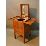 A Regency Mahogany Night Stand, the double hinged top enclosing a pull up mirror above two doors and