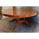 A Large Walnut Circular Dining Table, the figural walnut and inlaid top above a quadruped base