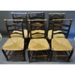 A Set of Six Elm Dining Chairs, the ladder backs with turned top rail above rush seats raised upon