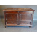 A George III Oak Mule Chest, the hinged top above a two panel front and two drawers flanked by