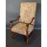 A Continental Walnut Armchair, the padded back and seat with scroll arms raised upon scroll supports
