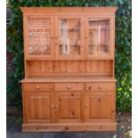 A 20th Century Pine Dresser, the moulded cornice above three glazed doors enclosing shelves, the