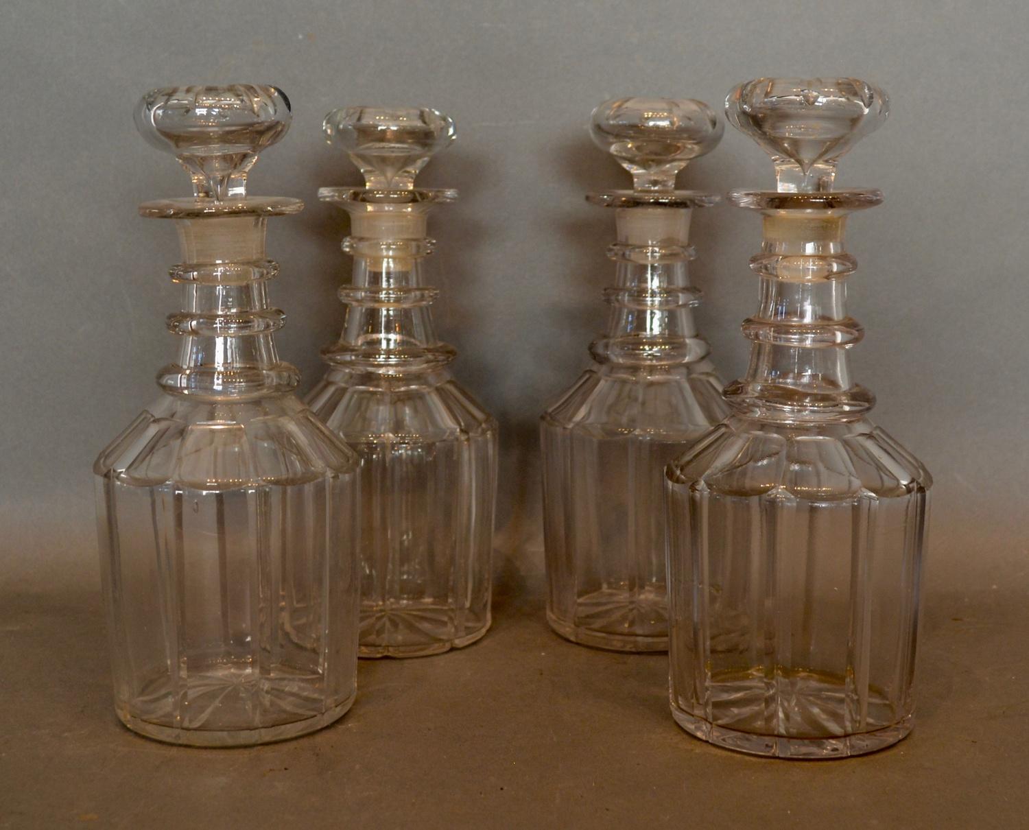 A Set of Four Early 19th Century Glass Decanters with stoppers with triple ring necks, 23cm tall