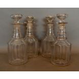 A Set of Four Early 19th Century Glass Decanters with stoppers with triple ring necks, 23cm tall