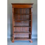 A 20th Century Hardwood Bookcase, the moulded cornice above open shelves flanked by turned pilasters