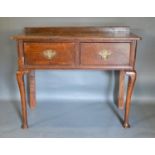 A George III Oak Lowboy with two drawers, brass swan neck handles, raised upon cabriole legs with