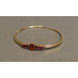 A 9 Carat Gold Bangle, set garnets, 8.9 grammes