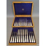 A Set of Twelve George V Silver and Mother of Pearl Handled Fruit Knives and Forks within fitted oak