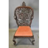 An Asian Carved Hardwood Low Seat Chair, the pierced shaped back above a drop in seat raised upon