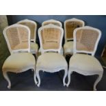 A Set of Six French Painted Dining Chairs, each with a cane back and upholstered seat raised upon