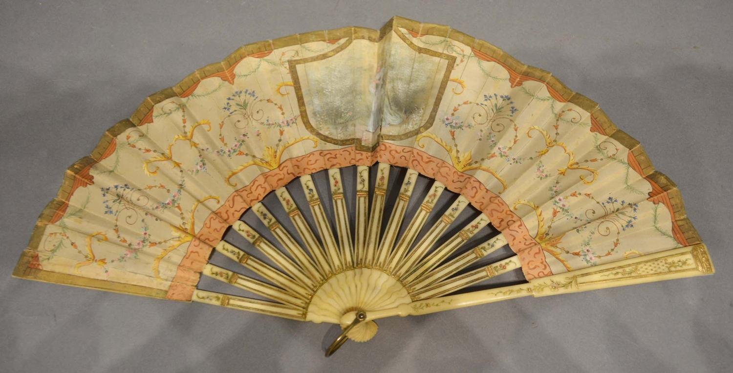An 18th Century Ivory Fan, the silk leaf hand painted with a cartouche, the sticks and guards